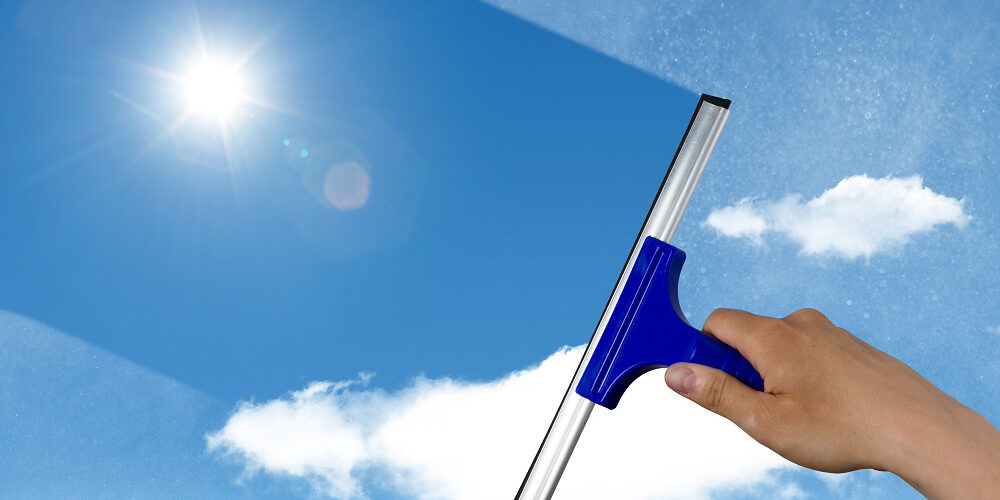 SaaS Apps, SaaS stacks, squeegee cleaning a dirty window, spring cleaning concept, blue sky