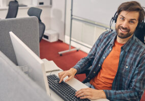 Contact Center employee smiling at desk