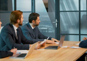 people sitting around conference table conducting hybrid meeting, using Kramer and Jabra conferencing solution