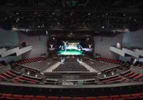 Closeup of auditorium with projector screen displaying Yaamava' Resort logo.