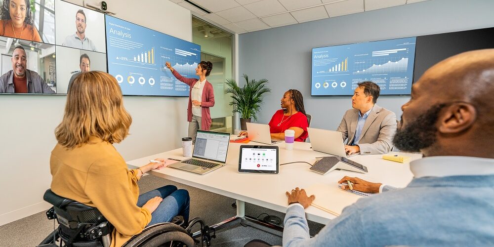 people sitting around large meeting room using Poly Studio Zoom Room bundle