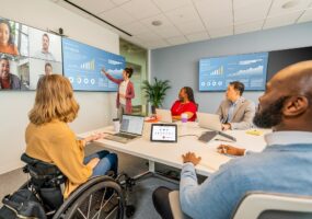 people sitting around large meeting room using Poly Studio Zoom Room bundle