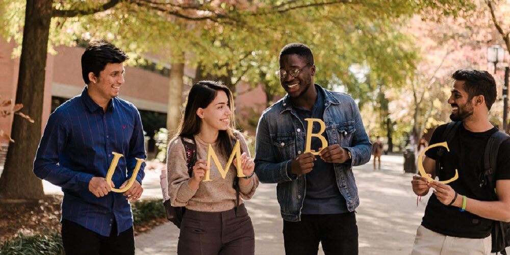 UMC international students holding UMBC letters